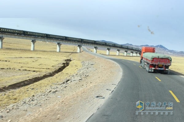 行駛在青藏公路上的卡車要穿越崇山峻嶺